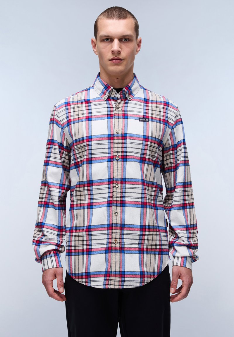 Camisa de botones con base blanca que presenta un patrón de cuadros en rojo, azul y beige. Material de algodón, mangas largas y dobladillo curvado.