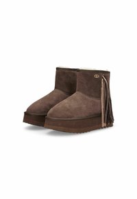 Stivaletti in suede marrone con un interno morbido e testurizzato. Presentano frange decorative ai lati e una suola spessa e scanalata per una migliore aderenza.