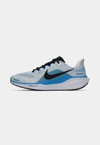 Világosszürke és kék Nike futócipő, fekete swoosh logóval és fekete fűzővel, oldalnézetből, fehér háttér előtt.