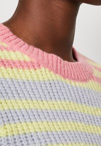 Pull tricoté multicolore avec des rayures rose pastel, jaune et lavande. Col rond côtelé et tissu texturé.