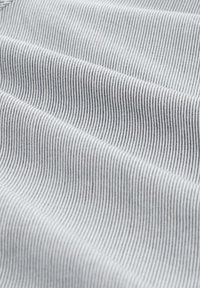 Baumwollstoff mit feinem, abwechselndem grauen und weißen Streifenmuster, das eine glatte Textur und einen weichen Fall aufweist.