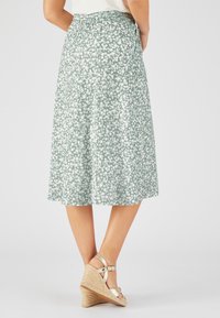 Gonna midi floreale in morbido tessuto verde chiaro con motivi di fiori bianchi, caratterizzata da una cintura elastica e una silhouette fluida.