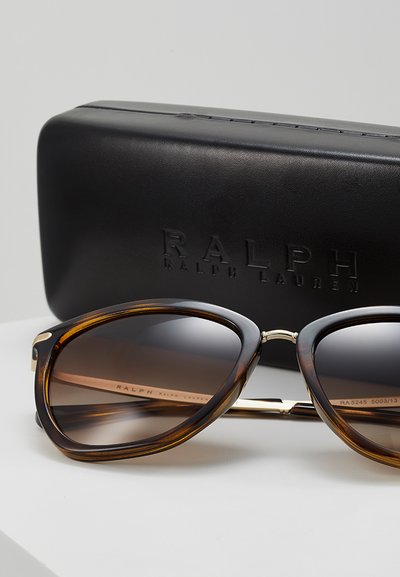 Rudos rudos vėžlio kiauto stiliaus saulės akiniai su auksinės spalvos tiltu ir metaliniais akcentais. Pateikiami su juodu kietu dėklu, ant kurio išspaustas "Ralph Lauren".