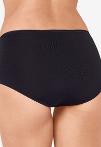 Zwarte damesonderbroek met een gladde textuur, hoge taille en een naadloze afwerking bij de tailleband en beenopeningen.
