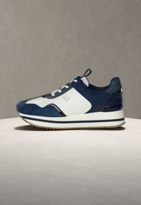 Σκούρα μπλε αθλητικά παπούτσια με πάνελ από σουέντ και δίχτυ, λευκά στοιχεία, λαστιχένια σόλα και κορδόνια στο μπροστινό μέρος. Λεπτός σχεδιασμός με υφή στο πίσω μέρος.