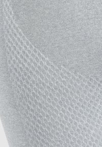 Lichte grijze leggings met een gladde textuur, een ribbelpatroon en een gestreepte zijpaneel voor extra detail en contrast.