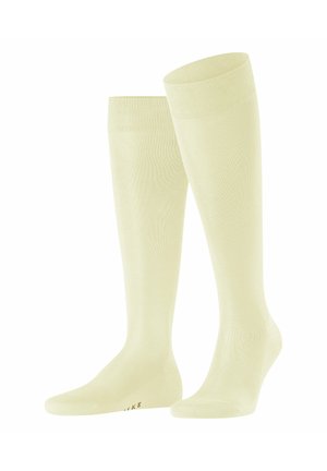 Calze al ginocchio di colore giallo chiaro, realizzate in un materiale morbido e elastico con un polsino a costine. Punta rinforzata e branding sottile sulla soletta.