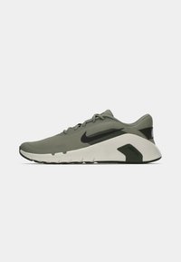 Chaussures Nike vert olive avec une tige en mesh, des accents noirs et une semelle intermédiaire blanche amortie. Équipées d'une semelle extérieure flexible pour plus de confort.