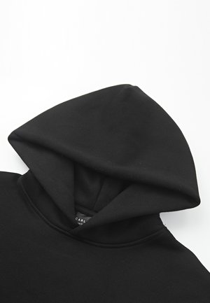 Felpa nera con cappuccio, caratterizzata da una morbida trama del tessuto, un cappuccio prominente e un'etichetta sul colletto. Design semplice e minimalista.