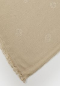 Beige vævet tæppe med subtile prægede mønstre, blød tekstur og frynser i kanten for ekstra detalje.