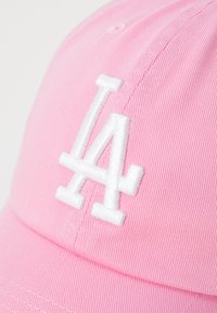 Rosa caps med ribbet tekstur har en hvit brodert "LA" logo på fronten. Designet inkluderer en buet skjerm og forsterket søm.