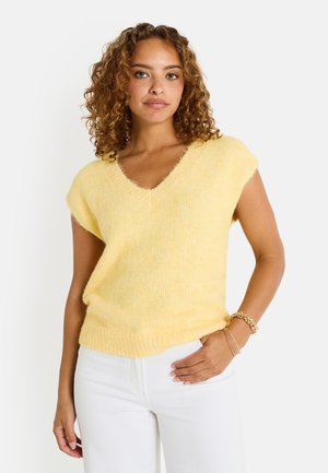 Suéter de punto amarillo de mangas cortas con escote en V, que presenta una textura suave y un dobladillo acanalado. Combinado con pantalones blancos, mostrando un ajuste relajado.