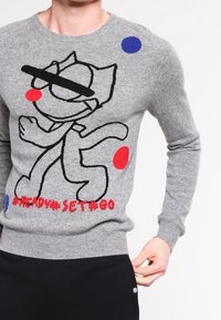 Grijs gebreide trui met een speelse cartoonontwerp met zwarte omlijningen, rode en blauwe stippen, en de tekst "#READY#SET#GO" in het rood.