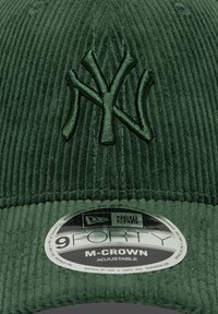 Πράσινο καπέλο από κορντούρα με κεντημένο λογότυπο NY, ρυθμιζόμενο λουράκι και κυκλικό ετικέτα New Era που αναγράφει τις πληροφορίες μεγέθους και μοντέλου.