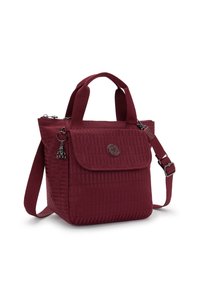 Maroon handbag made of textured fabric, featuring dual top handles, an adjustable strap, front flap, and decorative charm on the side.