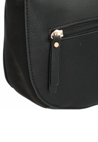 Borsa a tracolla in finta pelle nera con forma arrotondata, dotata di una tasca anteriore con zip e dettagli in metallo dorato. Superficie testurizzata.