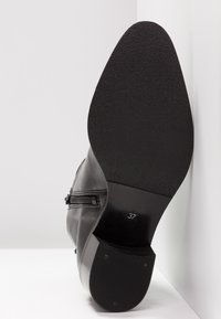 Stivale alla caviglia in pelle nera con suola texture, dotato di dettaglio con zip laterale e tacco di circa 3 cm, taglia 37.