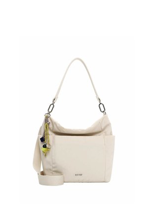 Beige schoudertas met brede band, voorvak en kleurrijke decoratieve bedeltjes die aan één kant hangen.