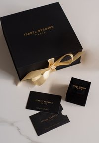 Zwarte cadeau-doos met gouden tekst, vastgebonden met een crèmekleurige lint; bevat een zwarte fluwelen ringdoos en twee zwarte kaarten voor certificaten.