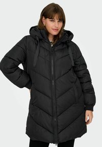 Black puffer coat with a hood, featuring a zip closure, chevron pattern, and ribbed cuffs. Made of quilted, insulated material.