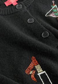 Cardigan negru din tricot, featuring trei butoane texturate. Decorat cu mărgele într-un design geometric și un motiv cu ruj în diverse culori.