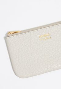 Helles graues Leder-Reißverschlussportemonnaie mit strukturiertem Oberflächenmuster, goldfarbigem Logo "BIMBA Y LOLA" und glattem Reißverschluss. Kompakte rechteckige Form.