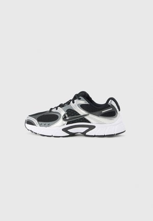 Scarpa atletica nera e argento con tomaia in mesh traspirante, colletto imbottito e suola in gomma testurizzata con un design distintivo.