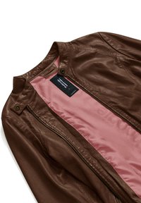 Giacca di pelle marrone con texture perforata, chiusura con zip e bottoni a pressione. Foderata con un morbido tessuto rosa. Etichetta visibile all'interno.