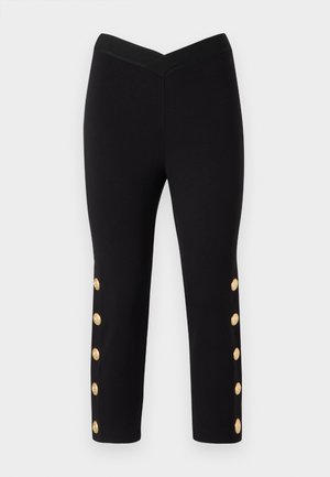 Pantalons capri noirs au design ajusté, dotés d'une taille côtelée et de boutons dorés sur les côtés extérieurs des jambes.