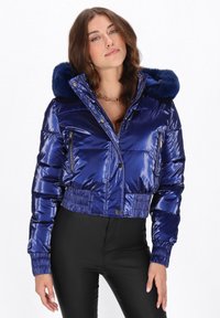 Krótka, błyszcząca granatowa kurtka puchowa z kapturem z futerkiem, kieszeniami na zamek i elastycznymi mankietami dla dopasowania.