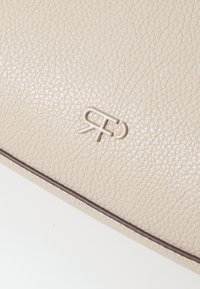 Beige textured leather clutch with embossed logo, featuring a dark brown trim. The surface displays a pebbled finish for added grip.
