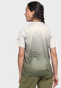 Back view of a short-sleeved, moisture-wicking shirt. Light gray fading to olive green, features text: "HEY NATURE, THANKS FOR THE RIDE."