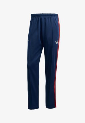 Ναυτικό μπλε αθλητικό παντελόνι με ελαστική μέση, διακοσμημένο με κόκκινες ριγέ πλευρές και λευκό λογότυπο. Κατασκευασμένο από λεία, υφασμάτινη υφή υλικό.