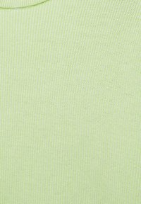 Gros plan d'un tissu tricoté côtelé vert clair avec un bord de col visible en haut, montrant la texture et de fines lignes verticales.