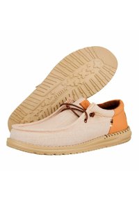 Scarpe da ginnastica beige in tela con dettagli in pelle arancione. Presentano un design con lacci, collare imbottito e suola in gomma testurizzata con battistrada a motivo.