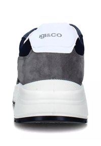 Sneaker con tallone in suede grigio, suola intermedia bianca e dettagli in blu navy. Presenta un logo su una patch bianca sul retro e una superficie testurizzata.