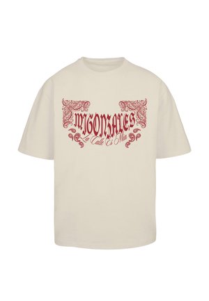 Krém színű póló, amelyen piros grafikával „MIGONZALES” felirat és díszítő spirálminták találhatók az elején. Klasszikus kerek nyakú és rövidujjú.