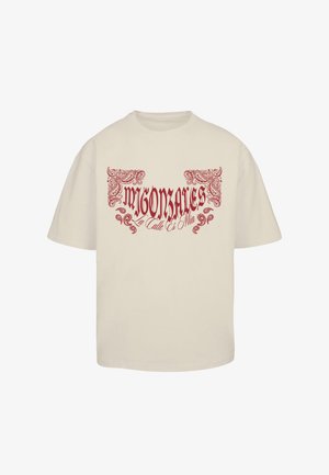 Krém színű póló, amelyen piros grafikával „MIGONZALES” felirat és díszítő spirálminták találhatók az elején. Klasszikus kerek nyakú és rövidujjú.