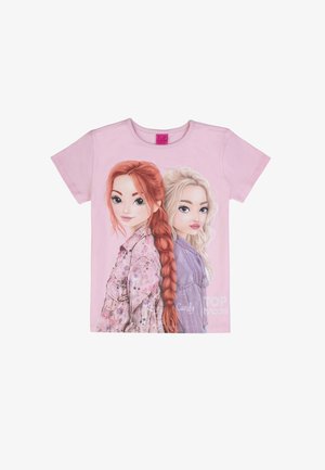 Camicetta rosa chiaro a maniche corte con due ragazze animate schiena contro schiena, una con i capelli rossi intrecciati, l'altra con i capelli biondi, etichettate come "Lucy" e "Candy".