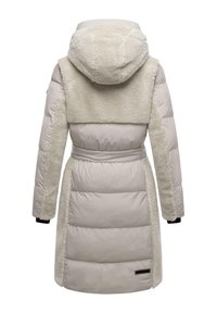 Lange beige pufferjas met nepbontaccenten op de capuchon en schouders, een ceintuur in de taille, en zwarte mouwmanchetten. Gladde, gestructureerde afwerking.
