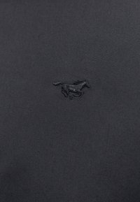Černé polo tričko z látky s vyšitým logem koně uprostřed. Textura je hladká s jemným leskem.