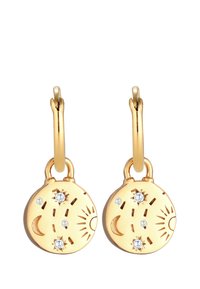 Boucles d'oreilles en or avec des pendentifs ronds ornés de motifs de soleil et de lune. Accentées de petites pierres précieuses transparentes. Texture lisse et polie.