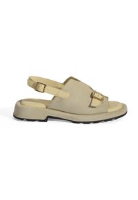 Beige Wildleder-Sandale mit einem geformten Fußbett, offenen Zehen, verstellbarem Schnallenriemen, Gummisohle und einem minimalistischen Design.