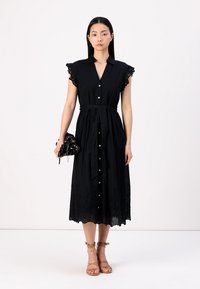 Melnas, pogājamās midi kleitas ar īsām, ruflētām piedurknēm, jostu maksimālajai novilcēšanai un ziedu mežģīņu akcentiem apakšmalā. Modelis tur atbilstošu somu.