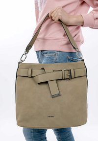Beige leather handbag with a textured finish, a decorative belt detail, silver hardware, and a short strap.