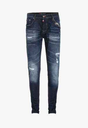 Donkerblauwe, slim-fit jeans van denim. Heeft versleten accenten, vervaagde gebieden en vijf zakken. Strak aansluitende pijpen met detaillering aan de zoom.