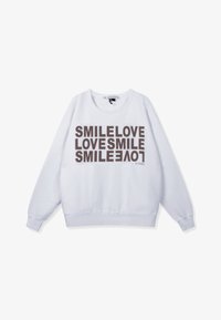 Sudadera blanca con texto en marrón oscuro que repite "SMILE LOVE LOVES SMILE" en orientación apilada y mixta. Cuello redondo, puños acanalados.