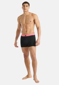 Czarne bokserki z różową elastyczną talią ozdobioną paskami i logo. Gładka tkanina, dopasowany krój i długość do połowy uda.