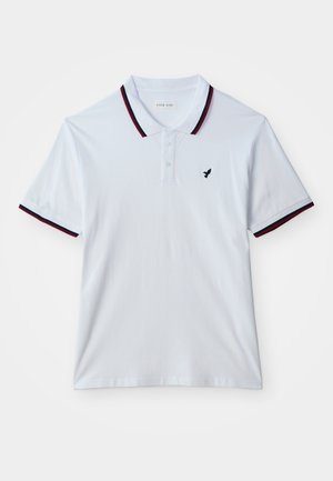 Polo bianca a manica corta con rifiniture nere e rosse su colletto e maniche, tre bottoni e piccolo logo nero di un uccello sul petto.