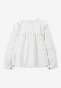 White long-sleeve blouse with a textured fabric, ruffled lace accents on shoulders, and embroidered details along the sleeves and back.